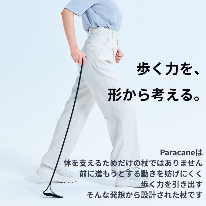 歩く人の足元とParacaneの杖。しなやかにしなる形状で、前に進む力を引き出す設計を表現している。